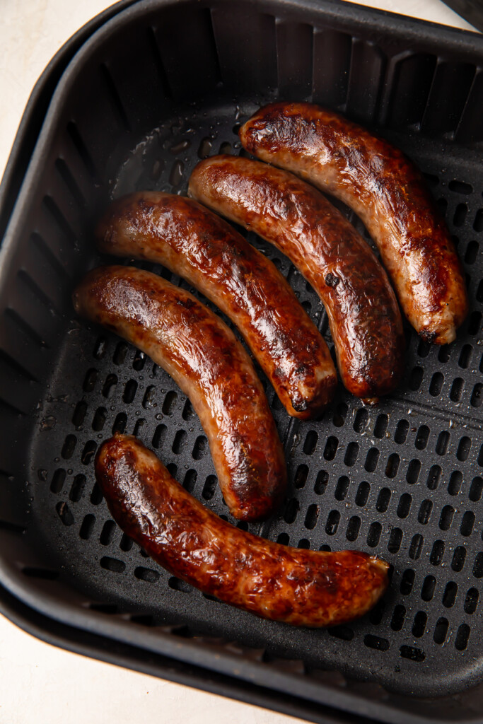 Cooked sausages in an air fryer basket