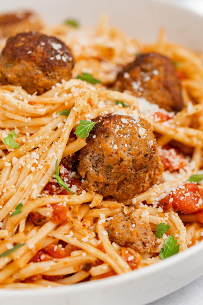 Close up image of keto spaghetti and meatballs with parmesan cheese and parsley on top.