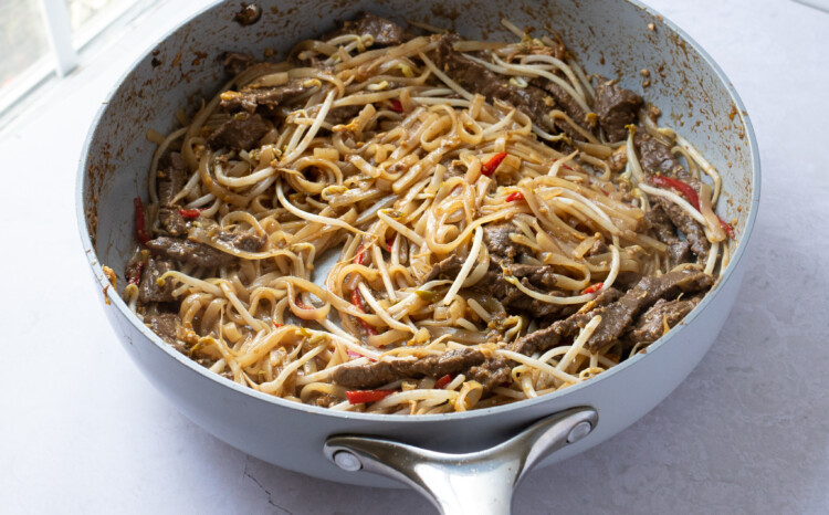 Beef pad thai with bean sprouts in large skillet