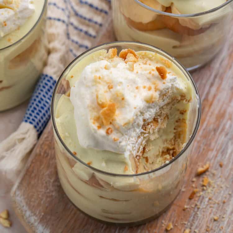 Overhead view of a portion of banana pudding with a spoonful removed to show the layers of pudding, bananas, and nilla wafers.