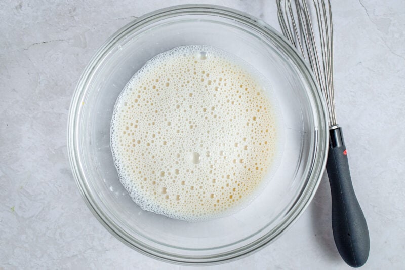 Almond milk and cornstarch in glass mixing bowl.
