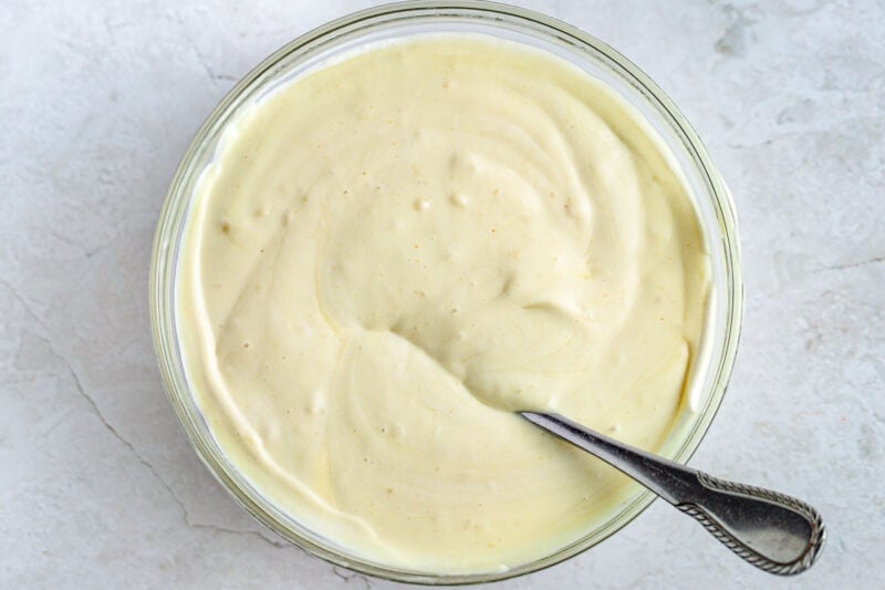 Vegan banana pudding in a large glass mixing bowl with a spoon.