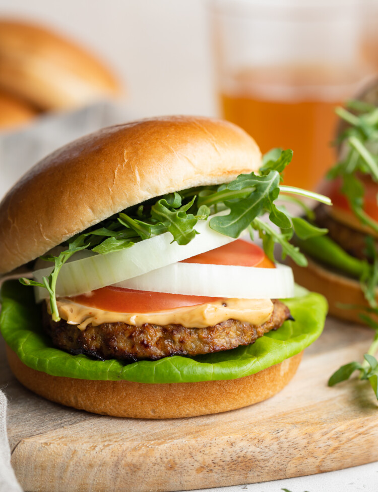 close-up image of an air fryer turkey burger with lettuce, tomato, onion, chipotle mayo, and arugula