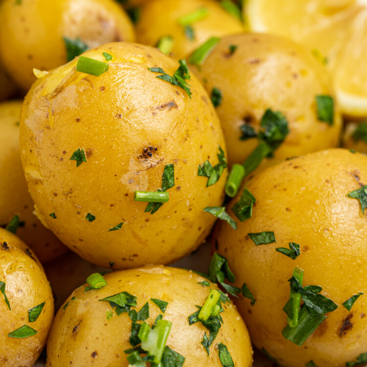 close up image of steam potatoes on a plate with a lemon