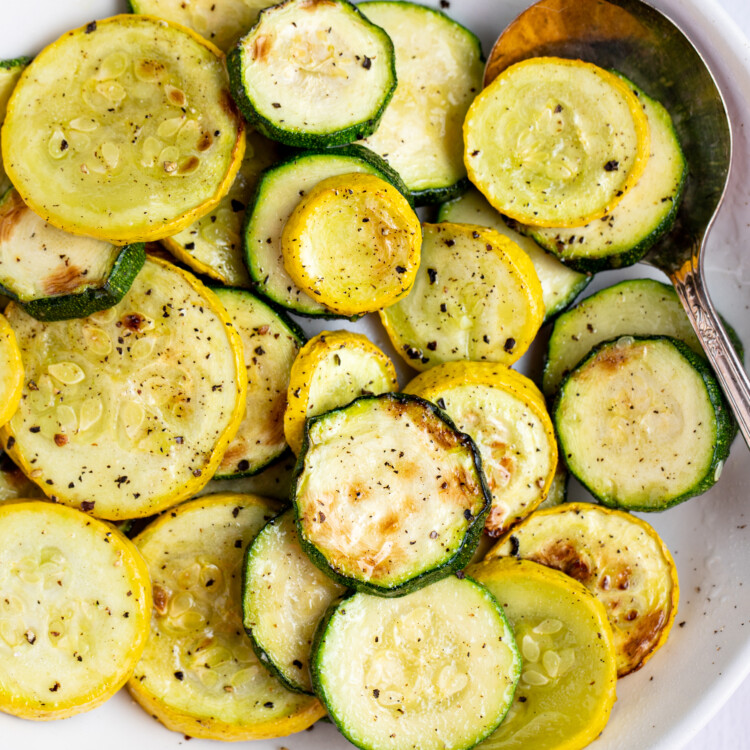 Close up of Air fryer squash and zucchini in a large bowl with a large spoon