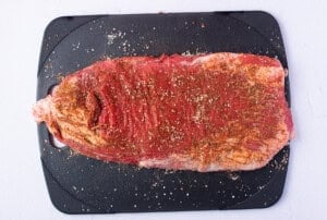 Seasoned flank steak on a cutting board