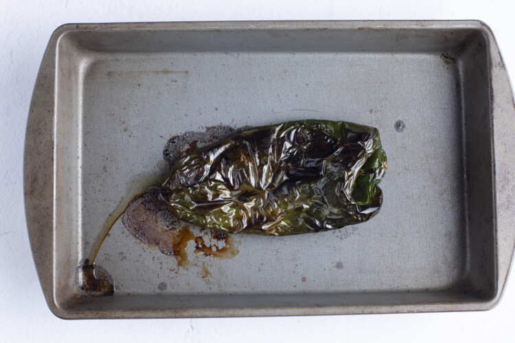 Charred poblano pepper on a baking sheet