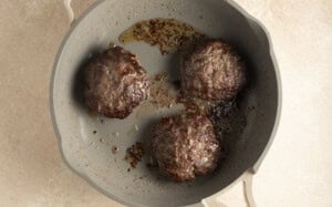 Cooked buffalo burger patties in large skillet