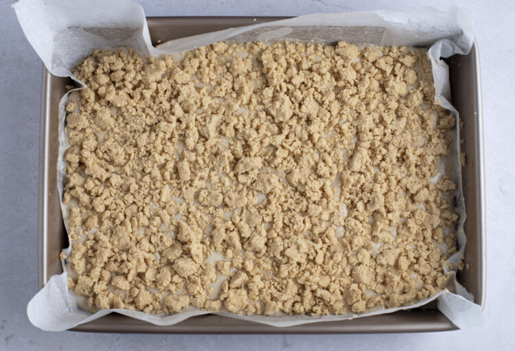 Top layer of vegan coffee cake in 9x13 baking dish with parchment paper