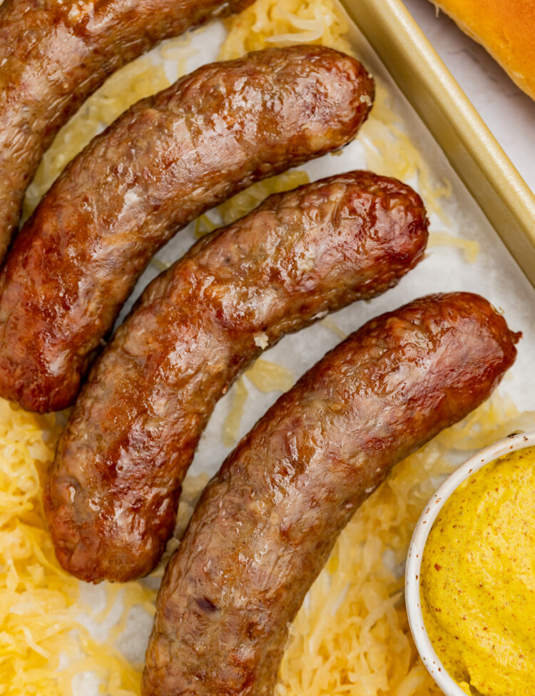 close-up image of air fryer brats with mustard on the side