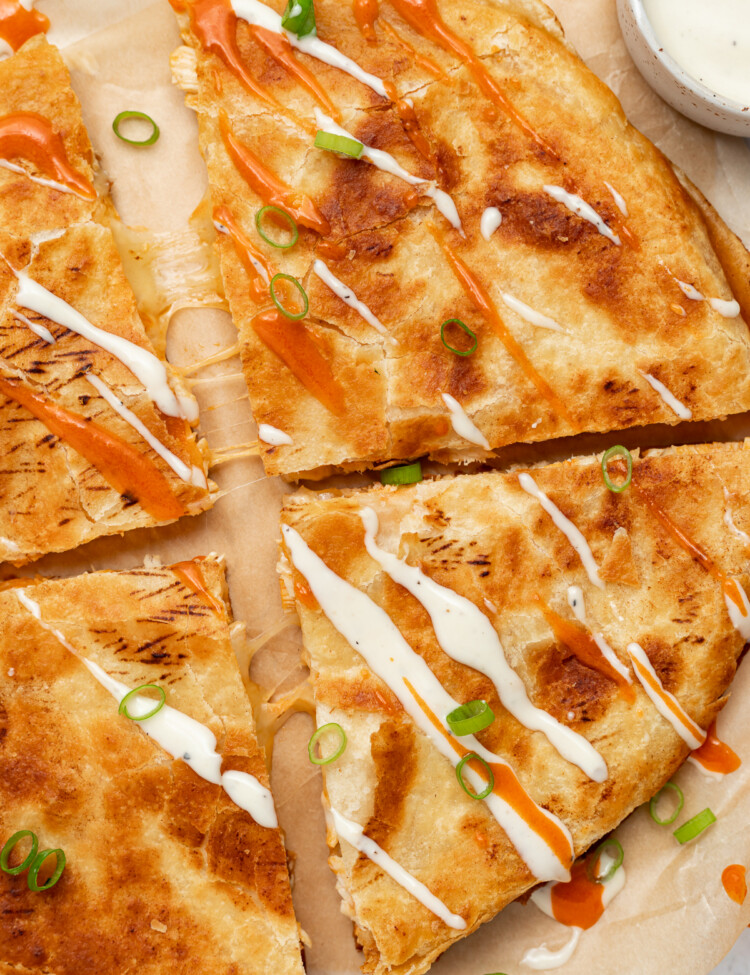 overhead image of buffalo chicken quesadillas with ranch dressing and buffalo sauce drizzled on top