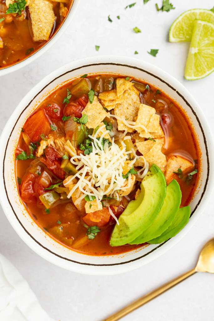 chili's southwest chicken soup in a bowl with crushed tortilla chips, cheese, and sliced avocado on top