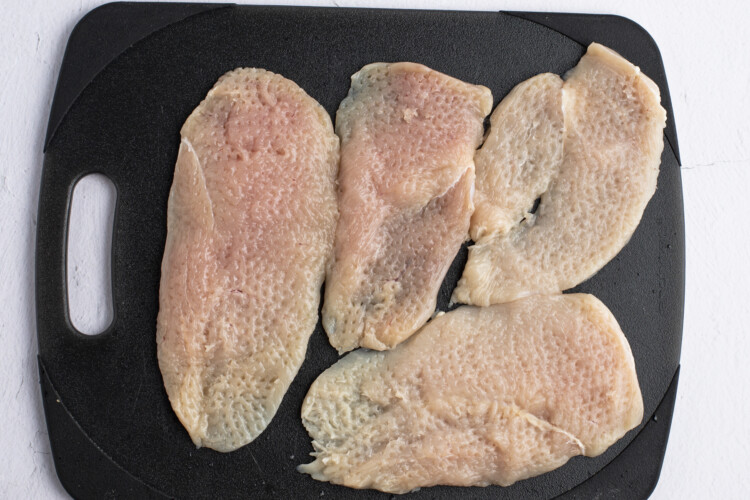 Chicken cutlets on cutting board