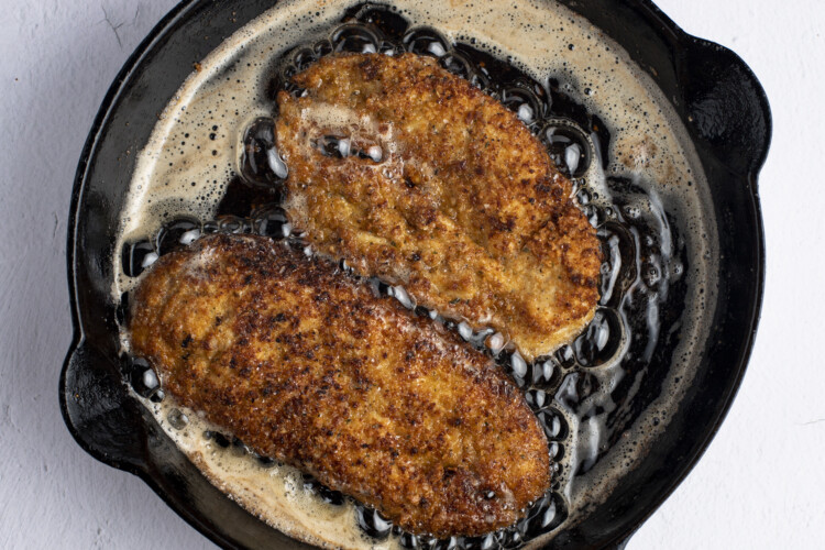 Pan-fried breaded chicken cutlets in skillet