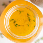 overhead image of instant pot turkey stock with fresh herbs on the side