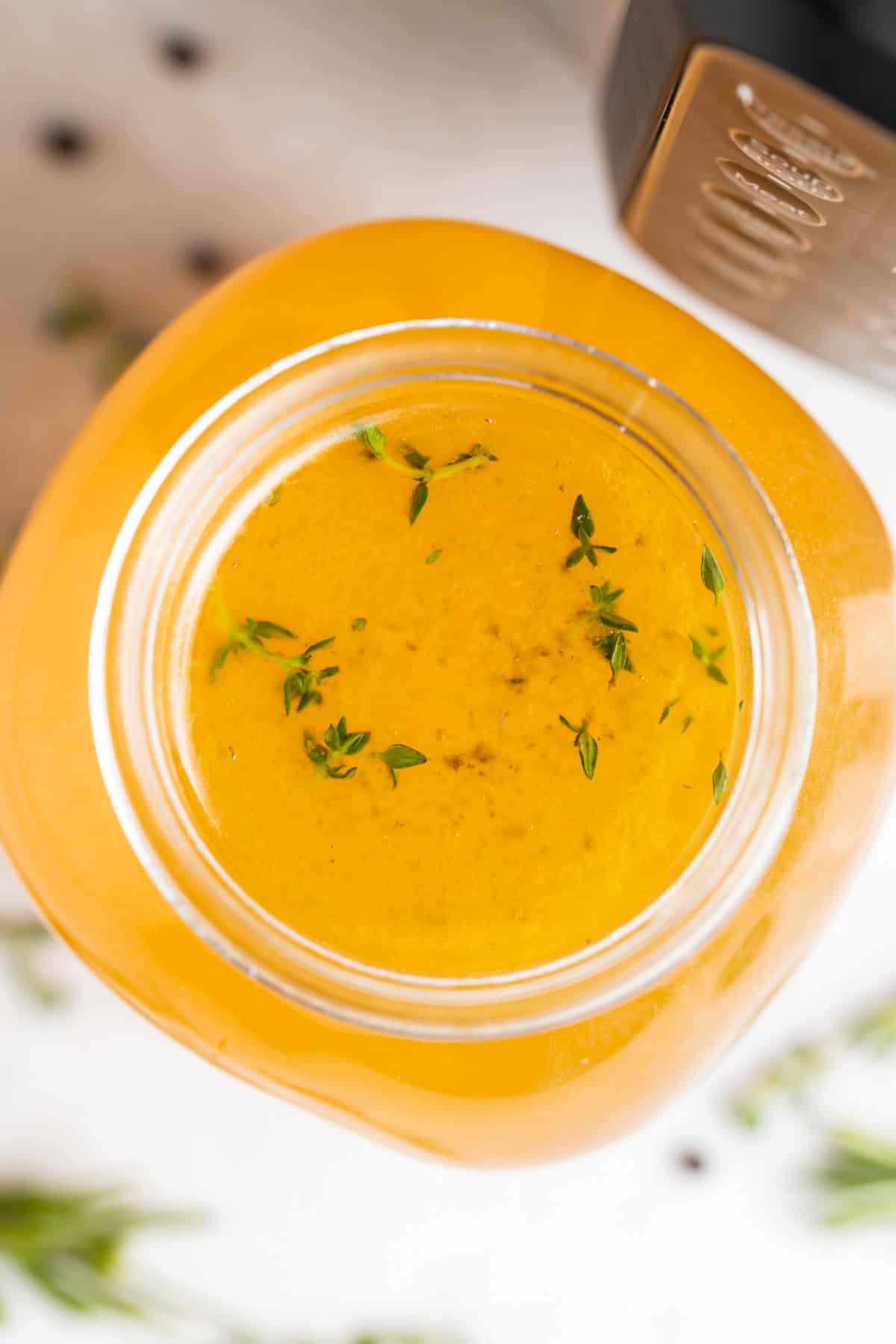 overhead image of instant pot turkey stock with fresh herbs on the side