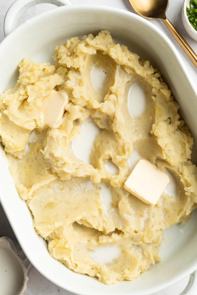 mashed potatoes in a baking dish with milk and butter