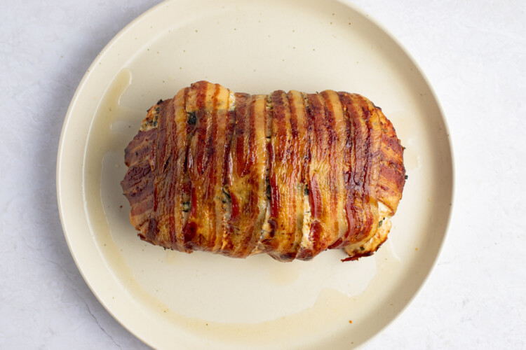 Cooked bacon wrapped turkey breast on plate