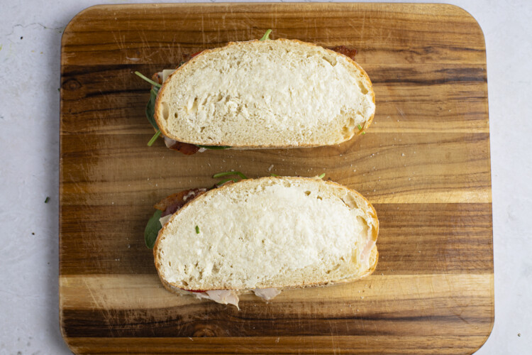 Buttered turkey melt sandwiches on cutting board