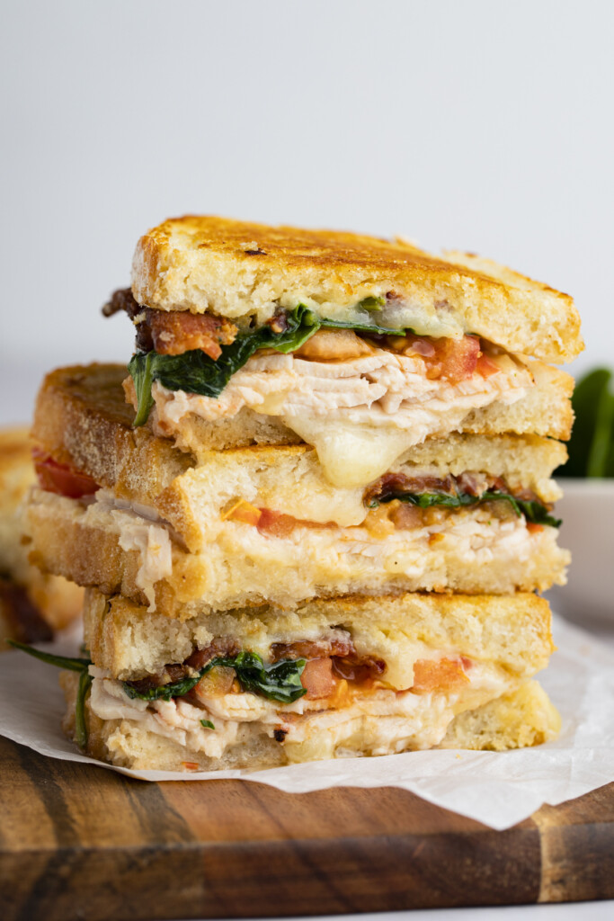 Three halves of a turkey melt stacked on top of each other 