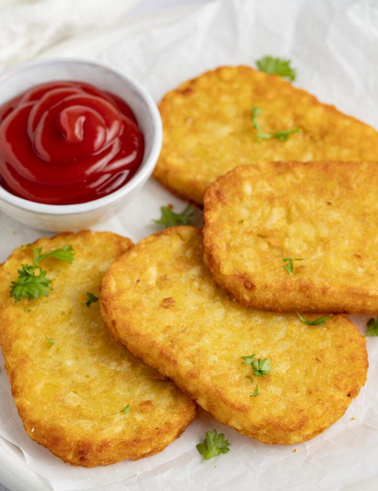 Hashbrowns in the air fryer served on a plate with ketchup