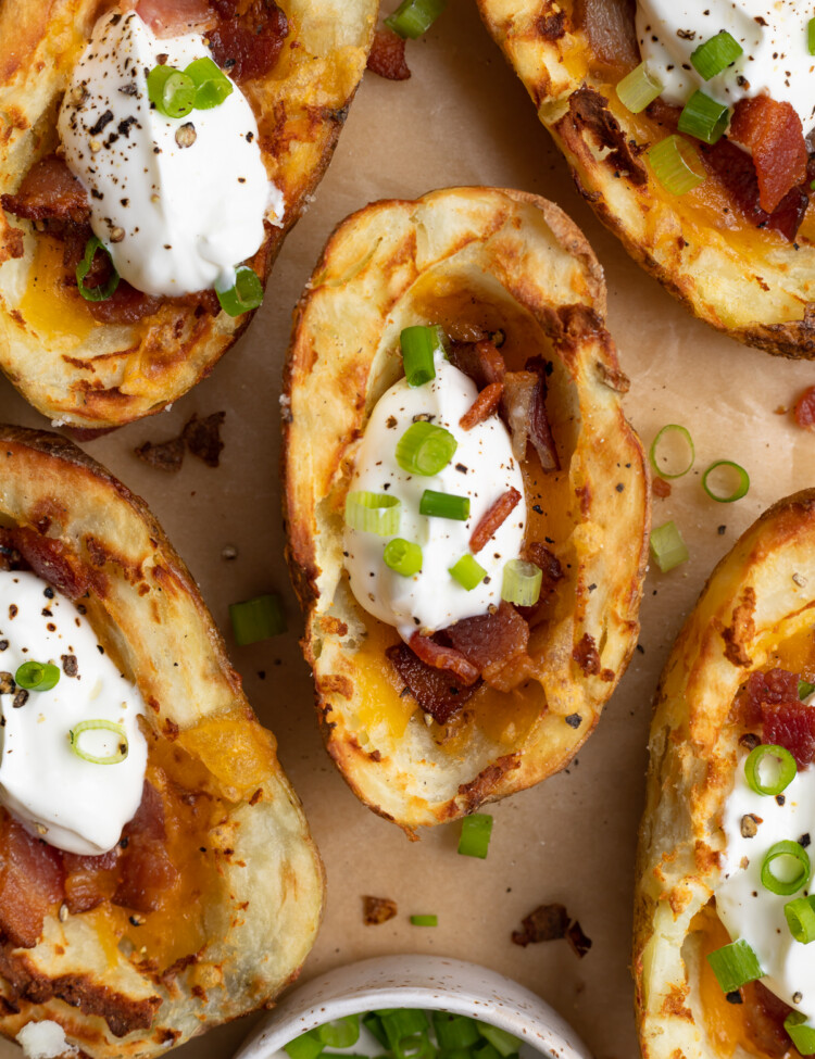 overhead image of air fryer potato skins with chopped green onion on the side