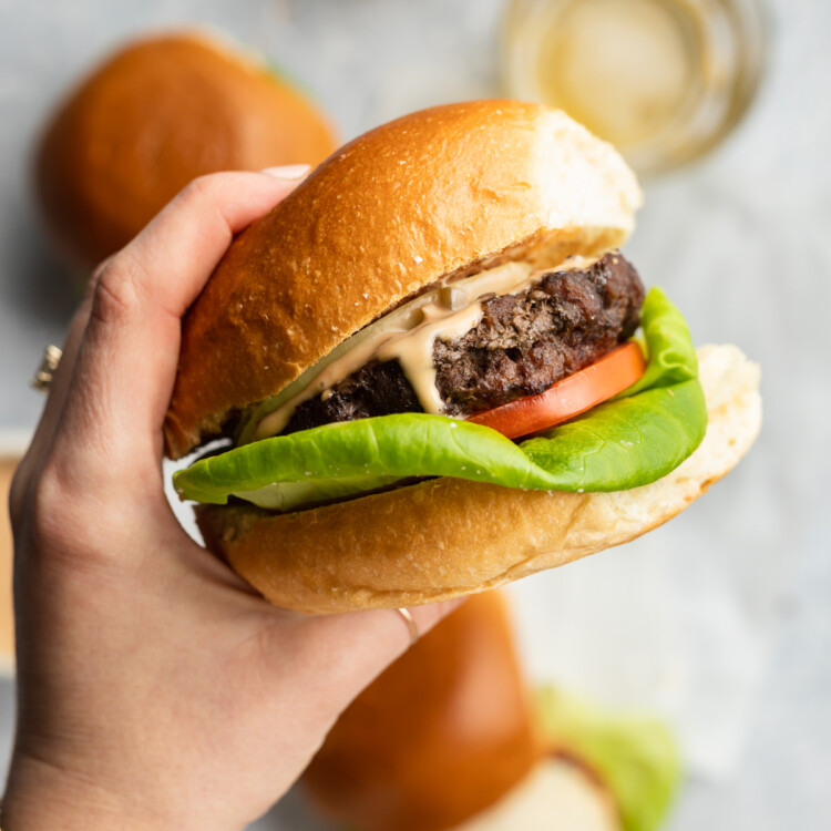 holding an air fryer frozen burger with special sauce in hand