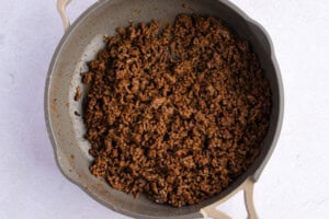 Keto tamale ground beef filling in large skillet on white background.