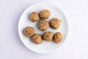 Keto masa dough rolled into balls on white plate on white background.