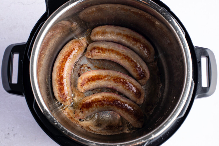 Overhead photo of bratwurst in Instant Pot with melted butter.