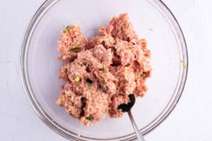 Ingredients for Asian turkey meatballs in a glass mixing bowl.