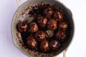 Overhead view of Asian turkey meatballs in sauce in a large skillet.