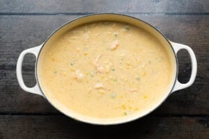 Overhead view of a large soup pot containing shrimp and corn soup seasoned with Old Bay.