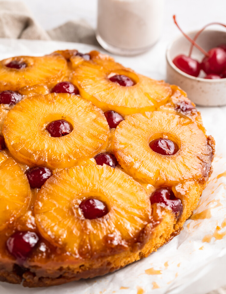 Close-up, 3/4 angle shot of a vegan pineapple upside down cake on a white table.