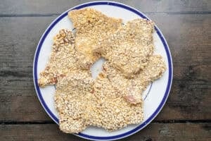 Overhead view of breaded beef schnitzel steaks on a plate.