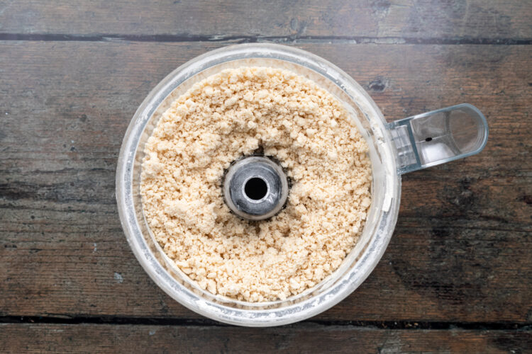 Overhead view of a food processor bowl of empanada dough ingredients.