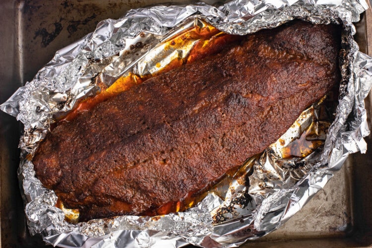 A rack of buffalo ribs on a baking sheet lined with foil.