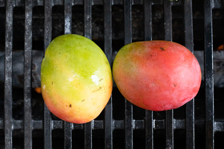 Mangoes cut-side down on grill.