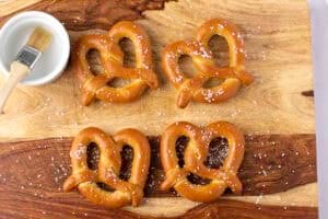 Overhead view of 4 soft twisted frozen pretzels on parchment paper.