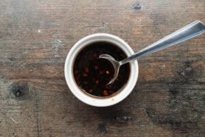 Overhead view of a dipping sauce for air fryer dumplings in a small ramekin on a wooden table.
