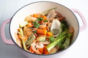 Overhead view of all shrimp stock ingredients in large dutch oven.