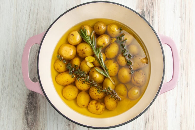 Baby potatoes with aromatics and garlic in a large pot with olive oil.