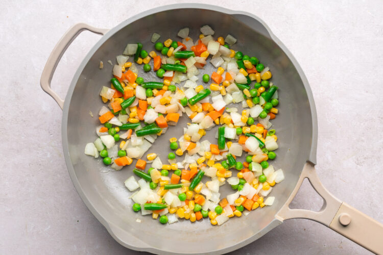 Mixed frozen veggies in a large skillet.