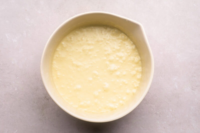 Wet ingredients for matcha brownies in a large mixing bowl.