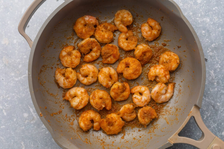 Seasoned, sautéed shrimp in a large skillet.