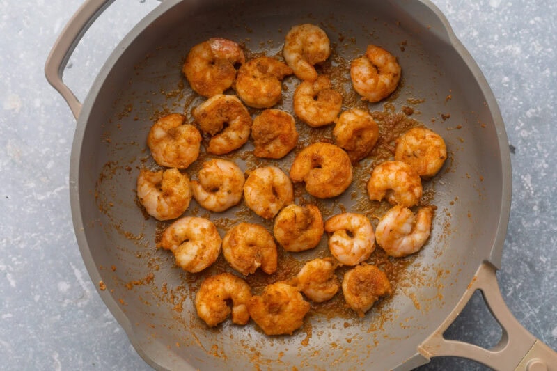 Seasoned, sautéed shrimp in a large skillet.