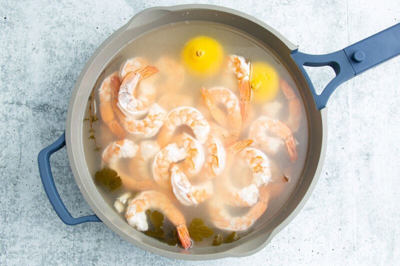 Poached shrimp in a large pot.