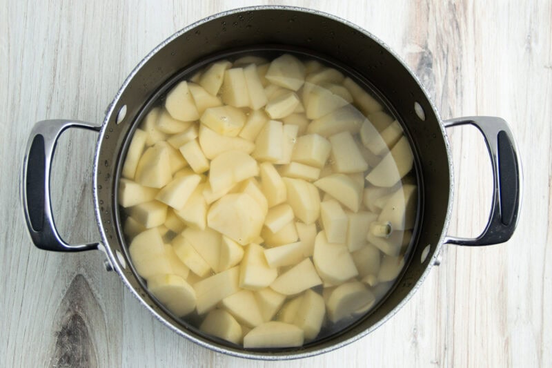 Cubed potatoes in a large pot of water.