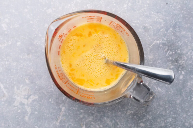Egg mixture in glass measuring cup.