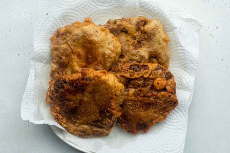 Battered and fried seitan fillets for vegan chicken sandwiches, resting on a plate lined with paper towels.